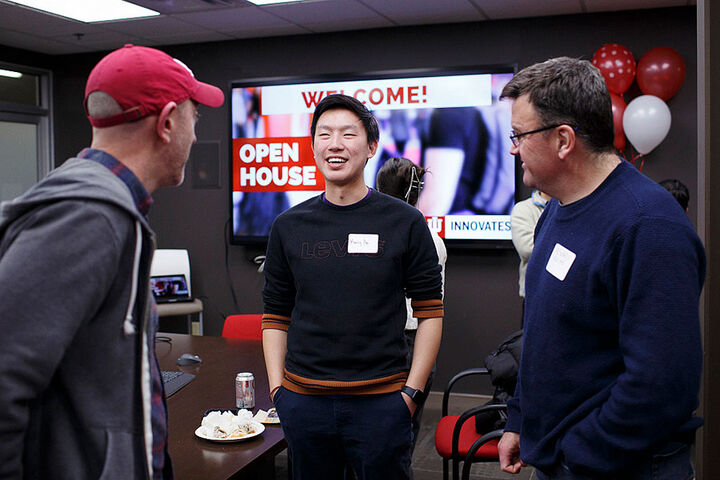 A group engages in conversation at an IU Innovates open house.